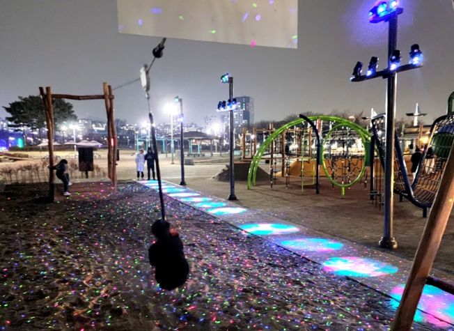상동호수공원에 관내 최초로 도입된 놀이형 경관조명에서 시민들이 집라인을 타고 있다.