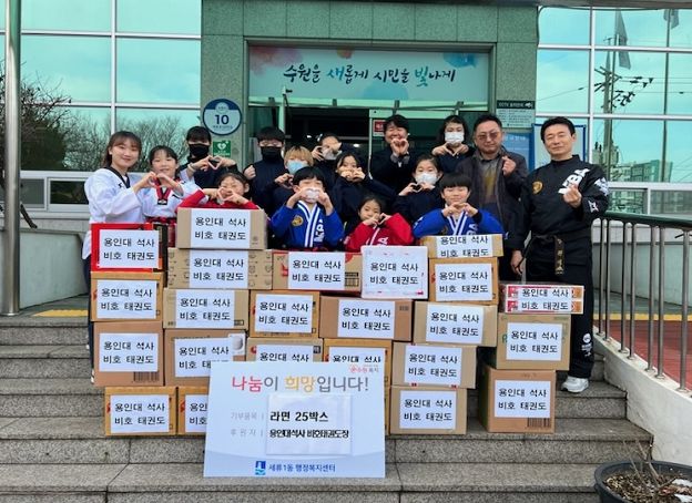 세류1동 관내 용인대 석사 비호 태권도 방원석 관장과 원생들, 세류1동 양은미 동장이 전달식에 참여한 모습