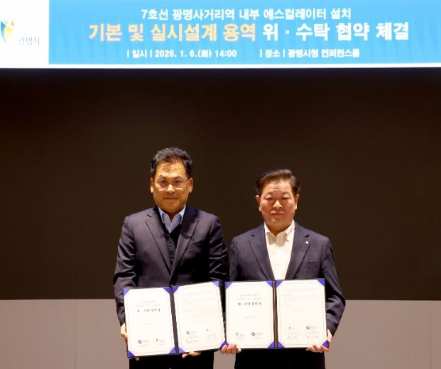 박승원 광명시장(사진 오른쪽)이 한우진 서울교통공사 토목처장과 ‘광명사거리역 내부 중앙계단 에스컬레이터 설치를 위한 기본 및 실시설계 용역 위수탁 협약서'를 들고 기념사진을 촬영하고 있다.