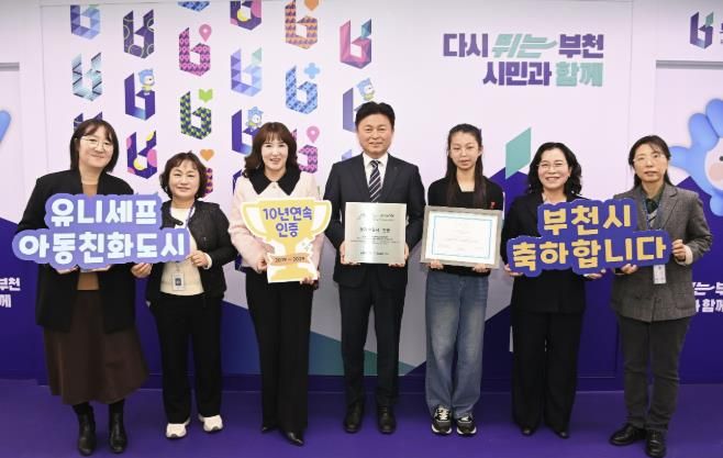 조용익 부천시장과(오른쪽 네 번째), 허정원 아동친화도시조성 추진위원회 부위원장(오른쪽 다섯 번째), 이서현 아동참여위원회 위원장(오른쪽에서 세 번째), 정애경 복지국장(오른쪽 두 번째), 아동보육과 직원들이 유니세프 아동친화도시 인증 기념사진을 찍고 있다.