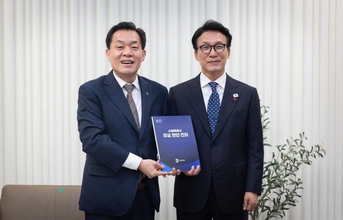 이재준 수원시장(왼쪽)이 김민석 국무총리에게 건의문을 전달한 후 기념촬영을 하고 있다.
