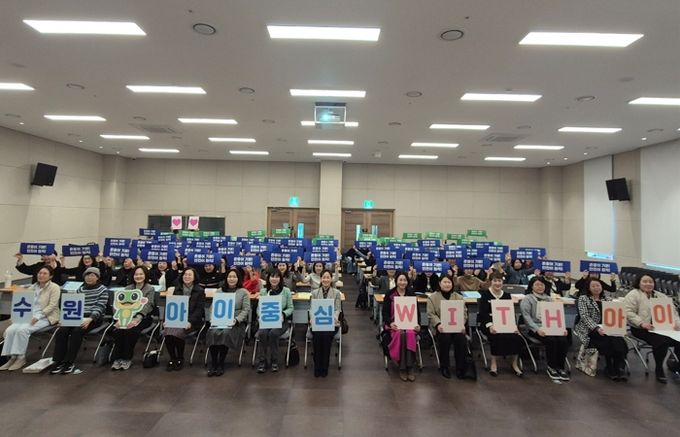 참석자들이 ‘수원, 아이중심 위드(WITH) 아이’ 슬로건 카드를 들고 기념촬영을 하고 있다.